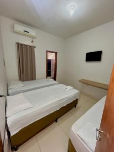 大瓦尔泽亚Kitnet Realeza的酒店客房设有两张床和电视。