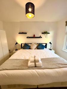 伦敦Stratford City - Luxe house with garden的一间卧室配有一张大床和毛巾