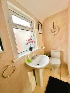 伦敦Stratford City - Luxe house with garden的一间带水槽、窗户和卫生间的浴室