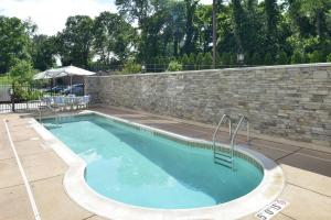 普鲁士王马洛特费城福吉谷/普鲁斯金春季山丘套房酒店的一座带砖墙和沥青的游泳池