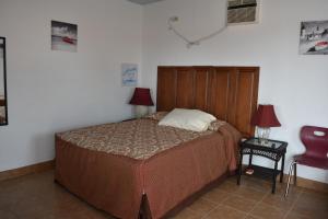 洛雷托Vistas de Loreto的一间卧室配有一张床和一张红色椅子