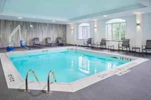 渥太华渥太华卡纳塔费尔菲尔德套房客栈的一个带桌椅的大型游泳池