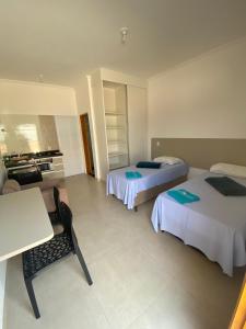 莫科卡Vaz Lobo Kitnets的酒店客房设有两张床和一张桌子。