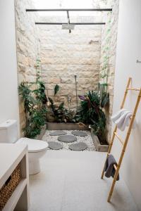 海神庙Shanti Boutique Retreat的浴室设有卫生间,地面种植了植物。