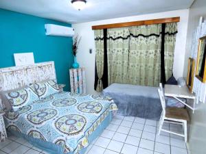 威廉斯塔德Apartment Rustic Curaçao的卧室配有1张床、1张桌子和1把椅子