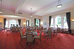 汉默温泉Hanmer Springs Hotel的宴会厅配有桌椅和窗户