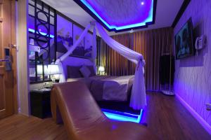 岘港Chiic House 1 - Khách sạn tình yêu的一间卧室配有一张紫色照明床