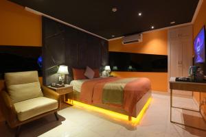 岘港Chiic House 1 - Khách sạn tình yêu的一间卧室配有一张床、一把椅子和电视。