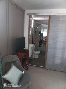 Anse-BertrandLe Domharry的一间带卫生间的浴室和一扇带电视的门