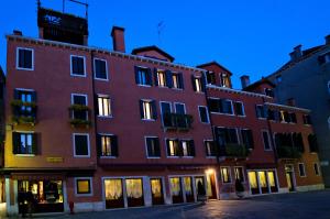 威尼斯帕拉佐百合酒店的一座红砖大建筑,灯火通明