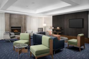 莱克兰Courtyard by Marriott Lakeland的客厅配有沙发、椅子和电视