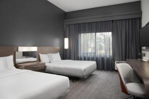 莱克兰Courtyard by Marriott Lakeland的酒店客房设有两张床和窗户。