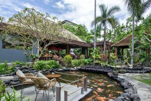 塞米亚克Tonys Villas & Resort Seminyak - Bali的房屋前带池塘的花园
