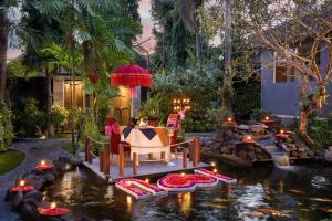 塞米亚克Tonys Villas & Resort Seminyak - Bali的池塘内带桌椅的花园