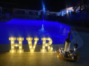 吉拉尔多特里卡德别墅酒店的表示晚上在游泳池旁快乐的标志