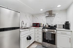 芝加哥Luxury chicago suite的厨房配有白色橱柜和不锈钢用具