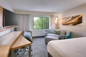 俄克拉何马城俄克拉荷马城西北万怡酒店的酒店客房配有一张床、一张桌子和一把椅子。