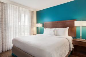 拉斯维加斯Residence Inn By Marriott Las Vegas Stadium Area的一间卧室设有一张大床和蓝色的墙壁