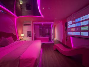 岘港Chiic House 2 - Khách sạn tình yêu的粉红色的卧室,配有床和投影屏幕