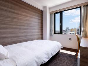 田边市ホテル紀伊田辺的一间卧室设有一张大床和一个大窗户