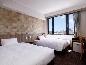 田边市ホテル紀伊田辺的酒店客房设有两张床和窗户。
