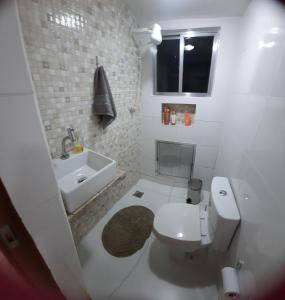 大伊瓜巴Iguabinha Duplex Pé na Areia的白色的浴室设有卫生间和水槽。
