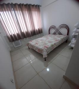 大伊瓜巴Iguabinha Duplex Pé na Areia的一间卧室配有床和带窗帘的窗户