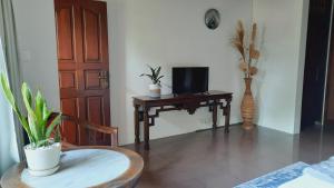 登巴萨Villia magnolia sanur bali 巴厘島玉蘭別墅的客房设有书桌、电视和椅子