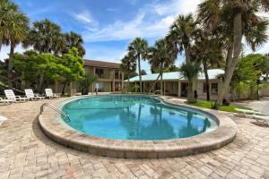 圣奥古斯丁海螺滨海度假村的一个带砖砌庭院和棕榈树的游泳池