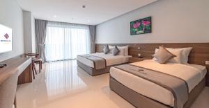 潘郎Long Thuan Hotel & Resort的酒店客房配有两张床和一张书桌