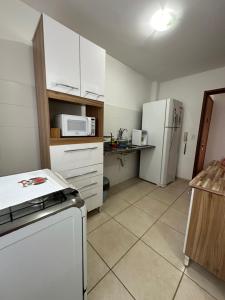 圣佩德罗-达阿尔德亚Apartamento em Condomínio Marinas Clube的小厨房配有冰箱和微波炉。