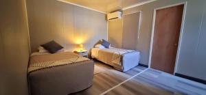 卡拉马HOSTAL SyR Calama的小房间设有两张床和椅子