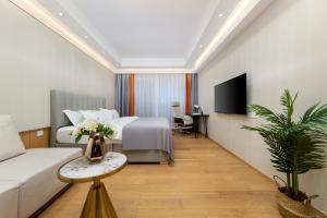 广州東枫国际公寓(广州国际金融城科韵路地铁站店)的一间酒店客房,配有一张床和一台电视