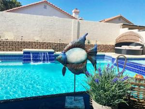 拉斯维加斯J’s amazing pool and hot Jaccuzi sweet house的一座孔雀雕像,站在游泳池旁