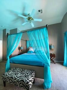 拉斯维加斯J’s amazing pool and hot Jaccuzi sweet house的一间卧室配有一张蓝色的床和吊扇