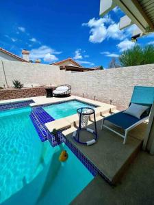 拉斯维加斯J’s amazing pool and hot Jaccuzi sweet house的一个带蓝椅和椅子的游泳池