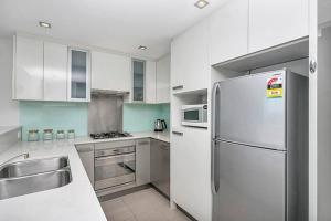 悉尼CBD Chinese Gardens Views, Modern 2BR Apt SX339的白色的厨房配有冰箱和水槽