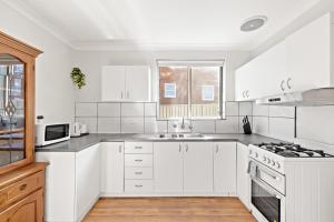 悉尼Premier Leichhardt Stayz的白色的厨房设有水槽和炉灶。