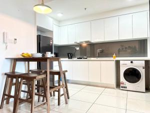 努沙再也2113 Almas Suites Studio100mbps! Netflix By STAY的厨房配有桌椅和洗衣机。
