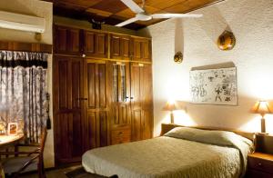 库马西Four Villages Inn的一间卧室配有一张床、一张桌子和一张书桌