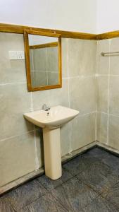 锡吉里亚Sigiriya Chena Villa的浴室设有白色水槽和镜子