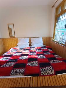 马拉里OYO Banka Guest House的一张床上有红黑色棉被