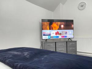 BraunstoneHometel Hidden Gem Large Comfy Home Can Sleep 13的卧室配有梳妆台上的平面电视