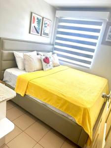 伊洛伊洛Spacious 2 bedroom 42sqm condo unit的一间卧室配有一张黄色毯子床
