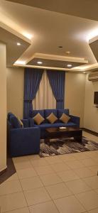 阿尔卡吉ريف الخرج 2 للشقق الفندقية的客厅,窗户前设有蓝色沙发