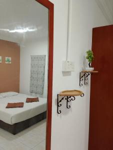 珍南海滩Lawer Guesthouse (Pulau Langkawi)的一间卧室配有一张床、一张桌子和一面镜子