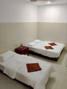 珍南海滩Lawer Guesthouse (Pulau Langkawi)的一间设有两张床和一张桌子的房间