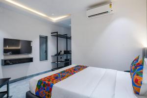 MadhapurFabHotel Prime Cloud 5 Studios的一间卧室配有一张床和一台平面电视