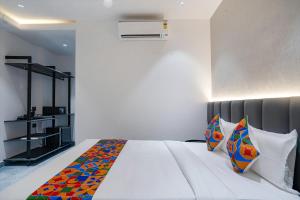 MadhapurFabHotel Prime Cloud 5 Studios的卧室配有一张带彩色枕头的大型白色床。