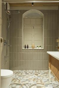 浦那Souzagad - Villa Maria的带淋浴、卫生间和盥洗盆的浴室